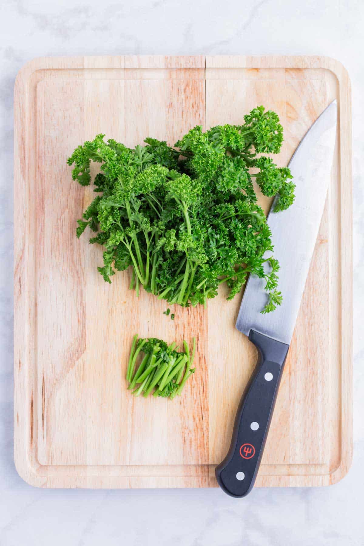 A sharp knife removes the thick stems of the parsley bunch.