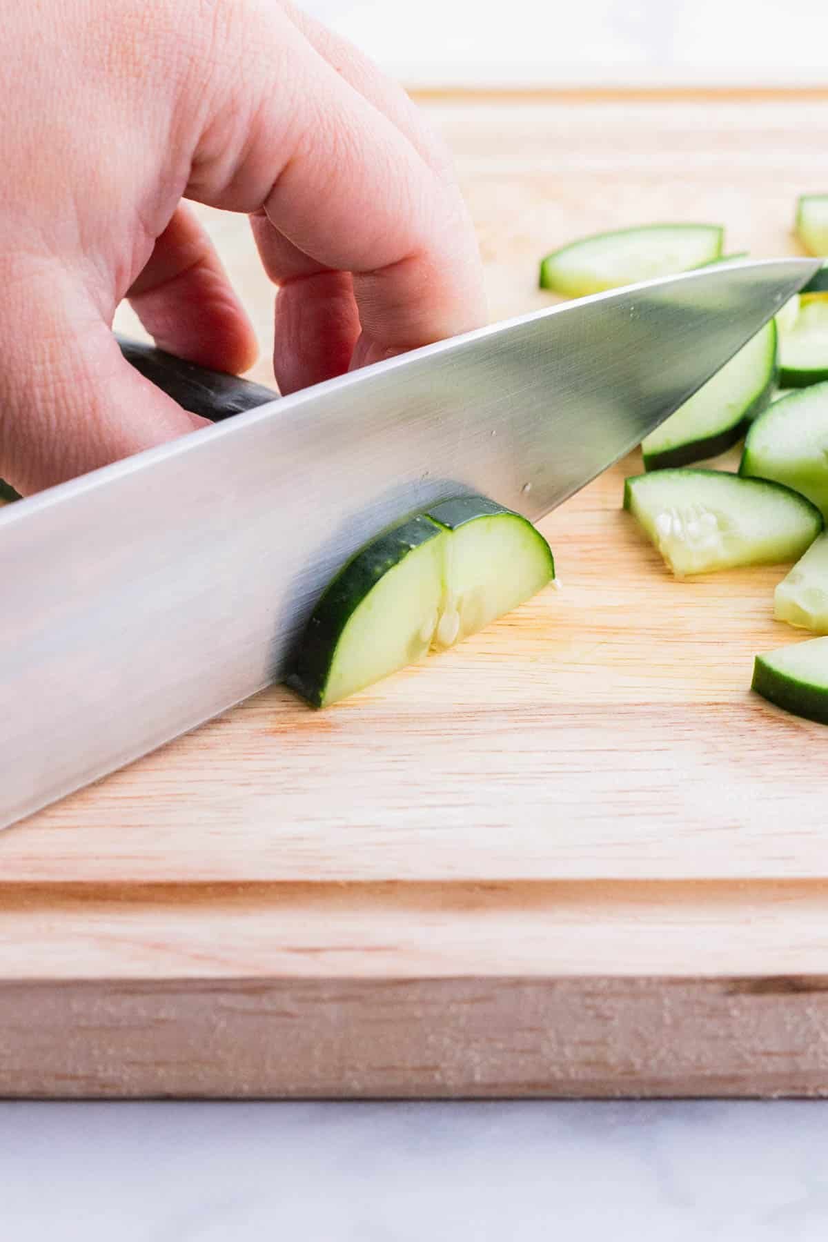 A half of a cucumber is sliced into half-moons.
