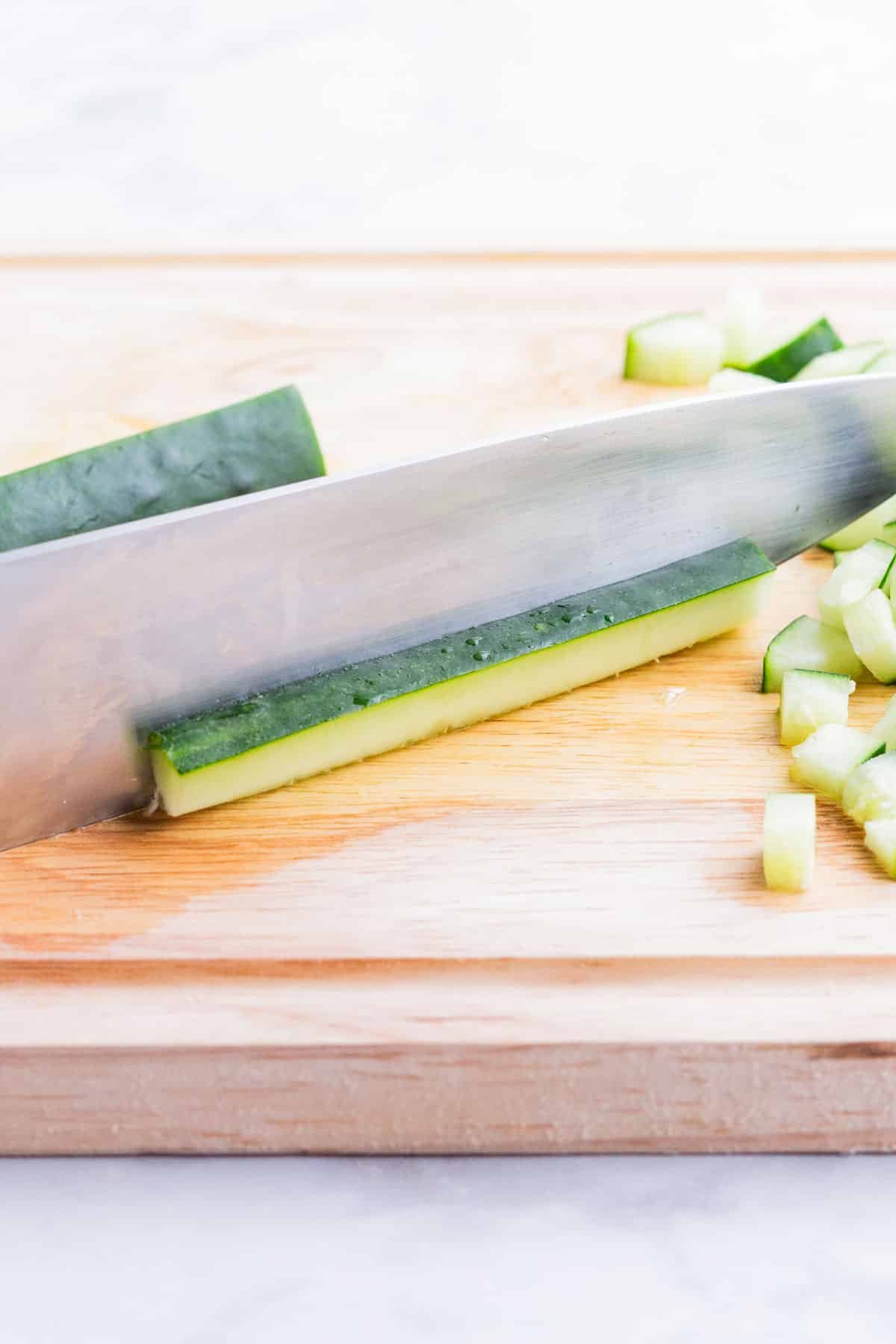 A chunk of a cucumber is cut into planks.