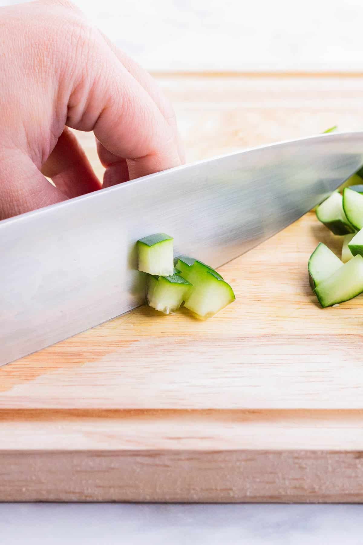 Cucumber planks are diced into pieces.