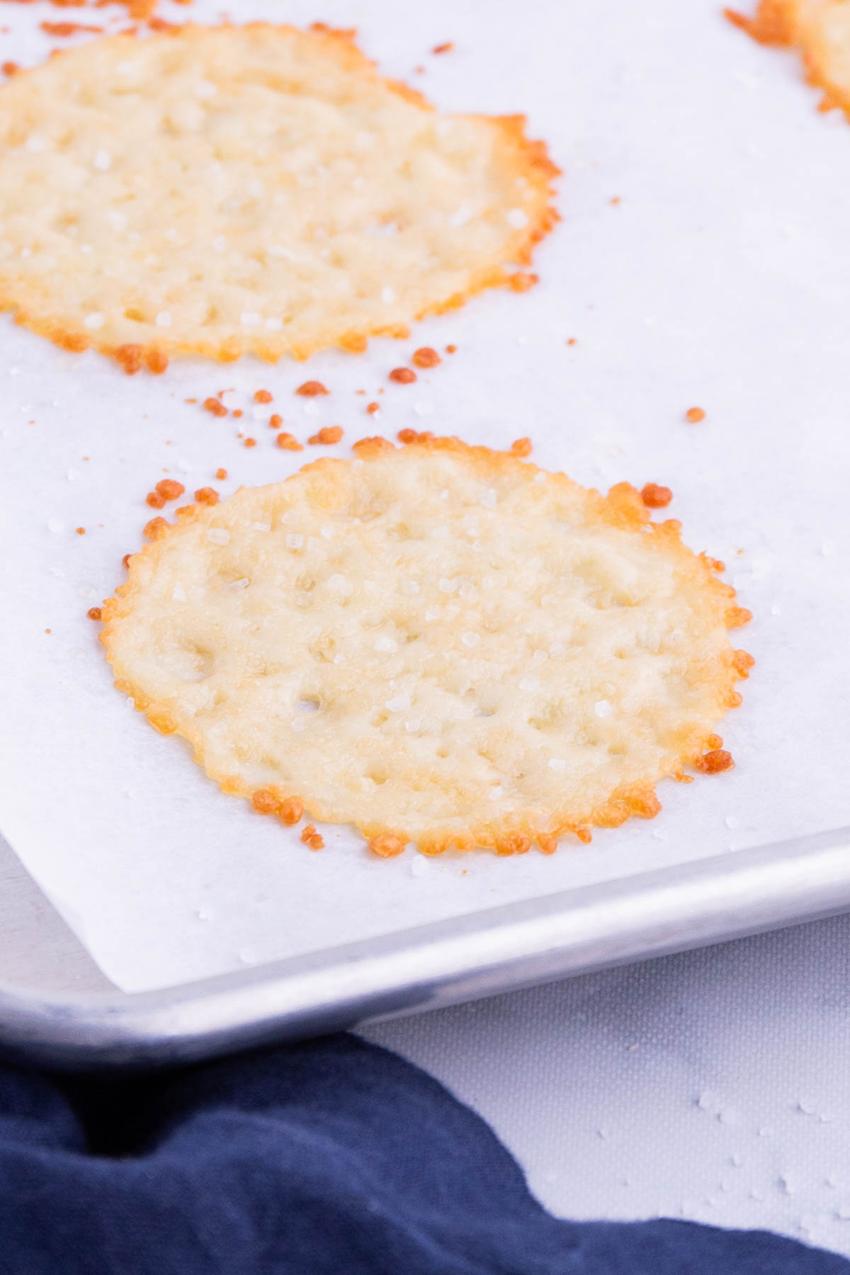 Parmesan crisps are baked on a cookie sheet.