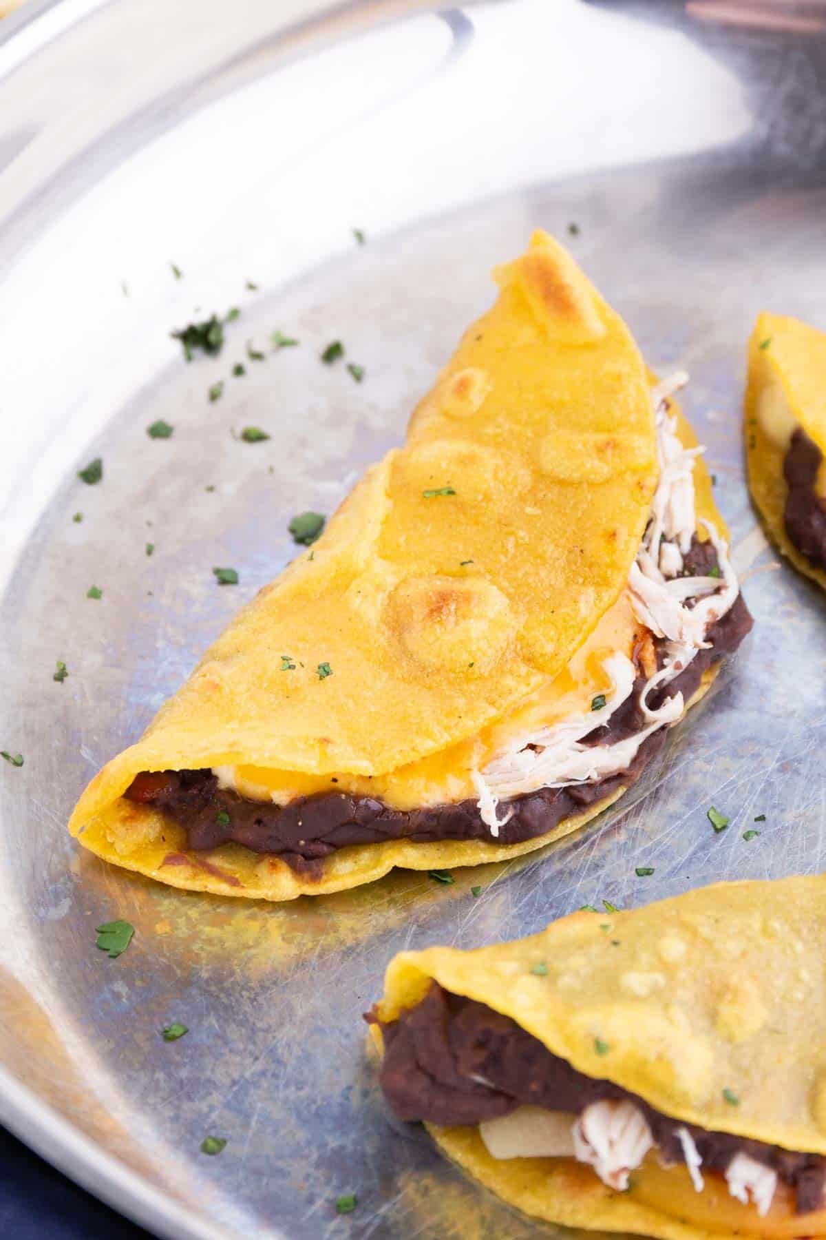 Corn tortillas are folded in half while cooking.