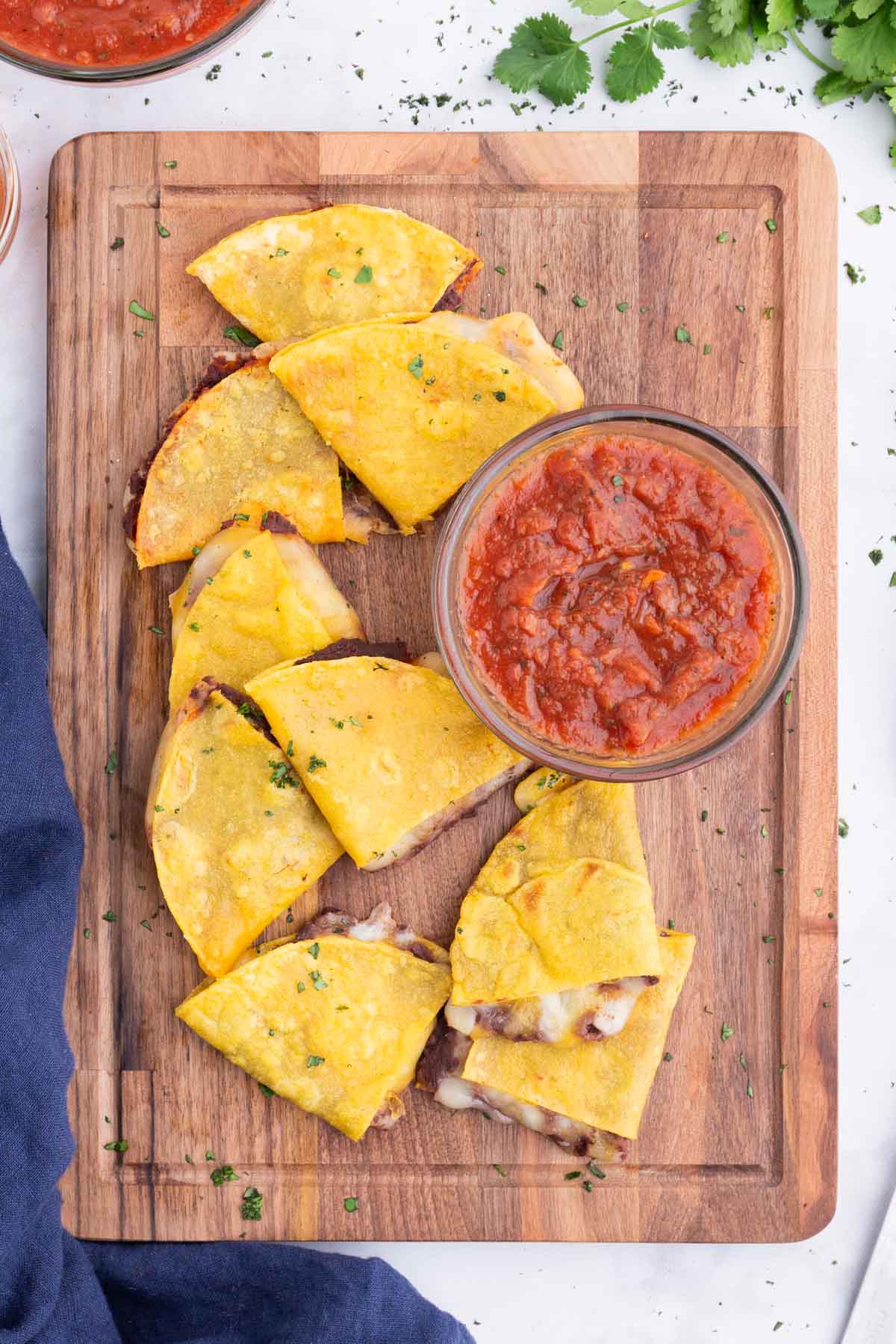 A stack of corn tortilla quesadillas are served on a tray.