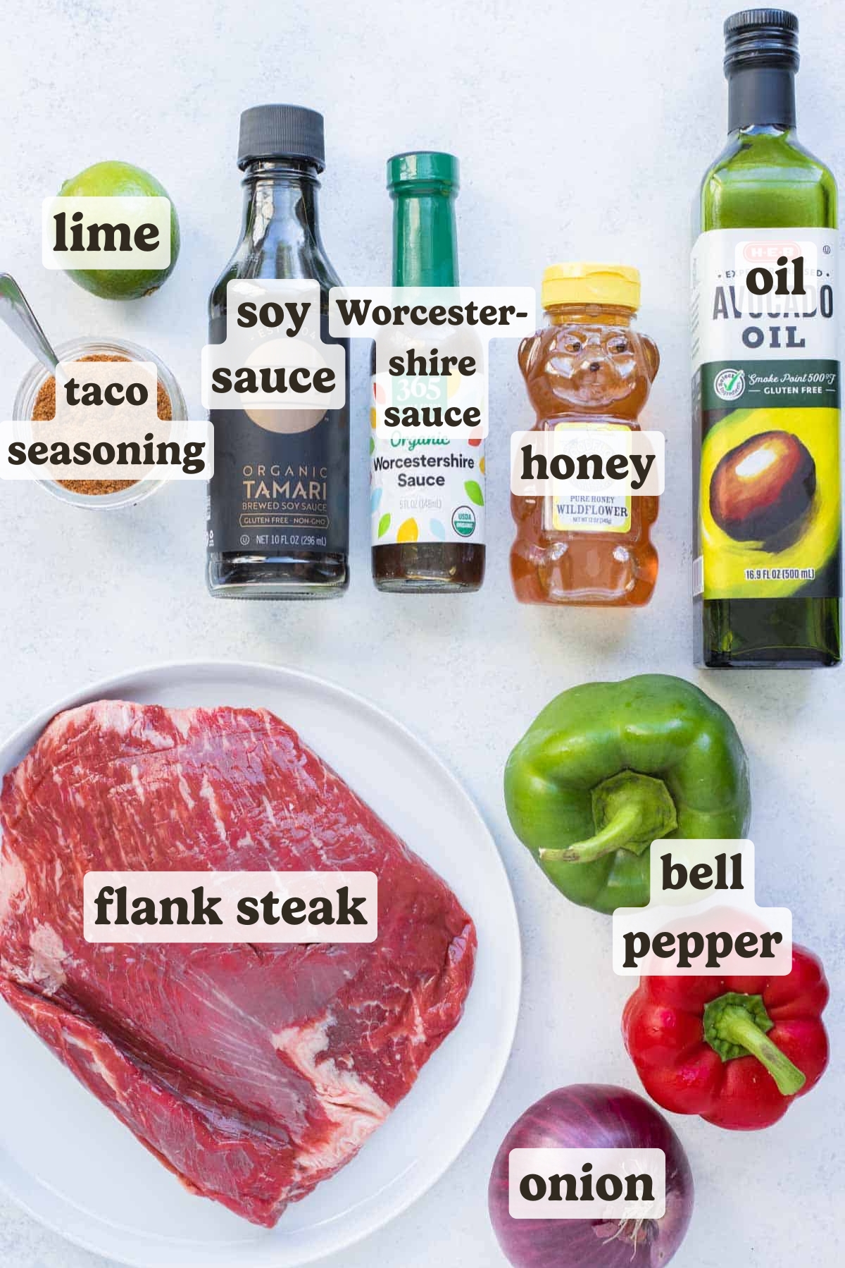 Labeled ingredients for homemade flank steak fajitas on a light background.