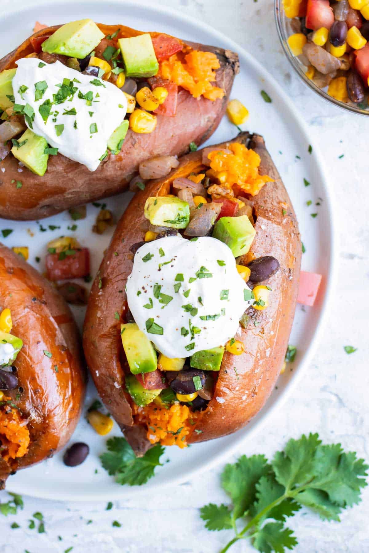 A baked sweet potato stuffed with black beans, corn, and avocado.