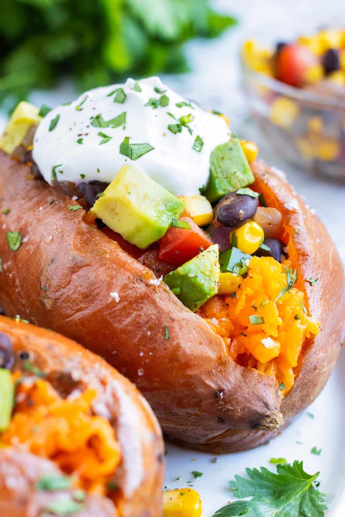 Mexican Stuffed Sweet Potatoes RECIPE served with sour cream and cilantro on top.