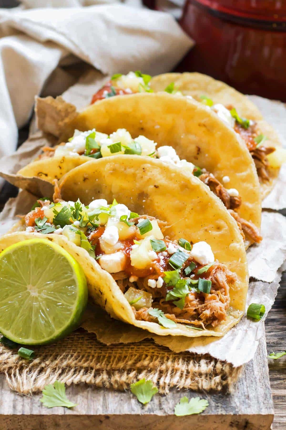 A row of delicious Slow Cooker Pineapple Pulled Pork Tacos for an easy lunch.