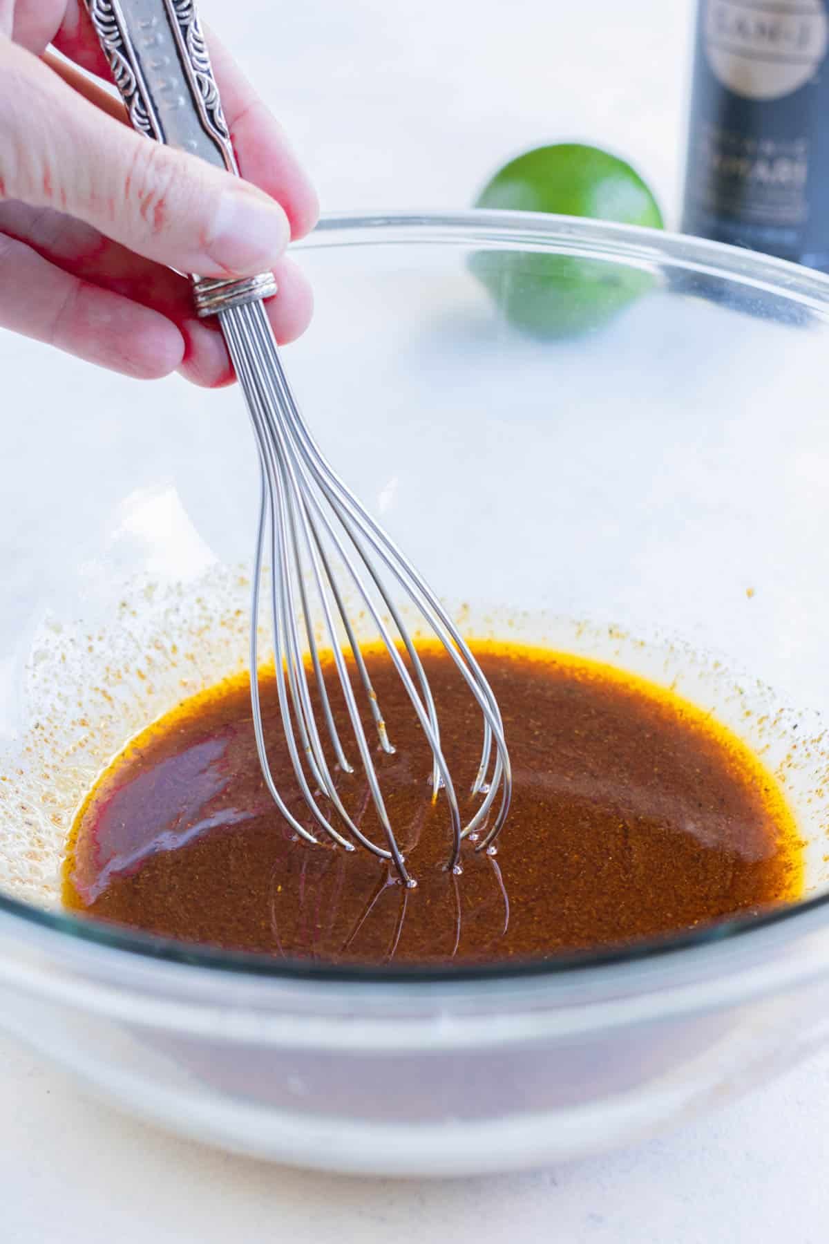 The fajita marinade is made by mixing the liquid ingredients and taco seasoning in a bowl.