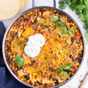 This beef taco skillet is topped with cheese and sour cream.