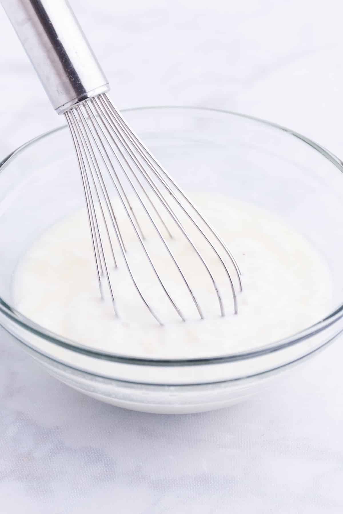 A yogurt sauce is whisked together.