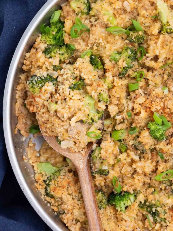 A wooden spoon is used to serve the broccoli rice mixture.
