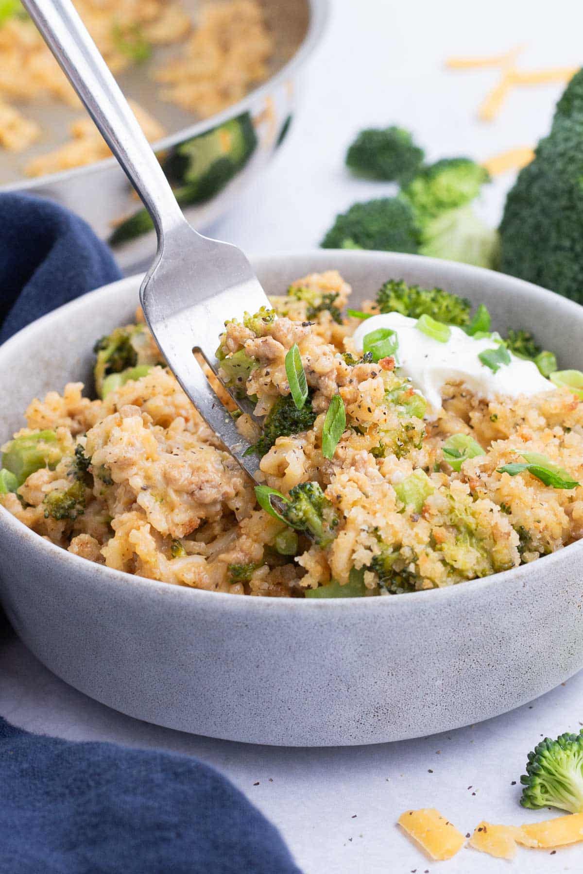 This cheesy broccoli and rice recipe is served up in a white bowl.