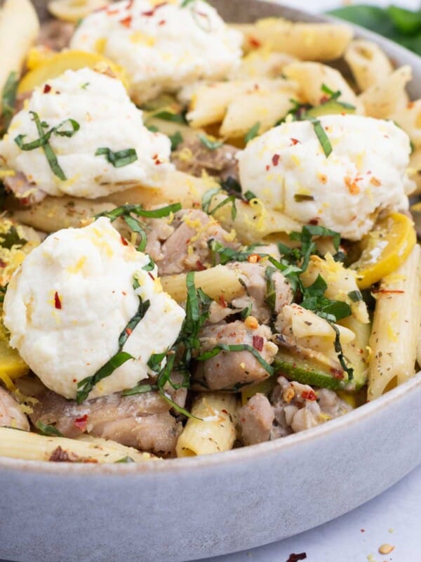 Pasta, veggies, and chicken are tossed with a lemon butter sauce and topped with ricotta cheese.