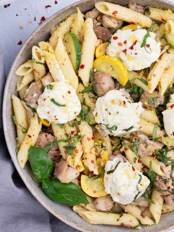 A lemon ricotta pasta is in a bowl with chicken.