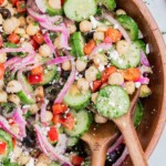 A wooden spoon is used to serve the Mediterranean chickpea salad.
