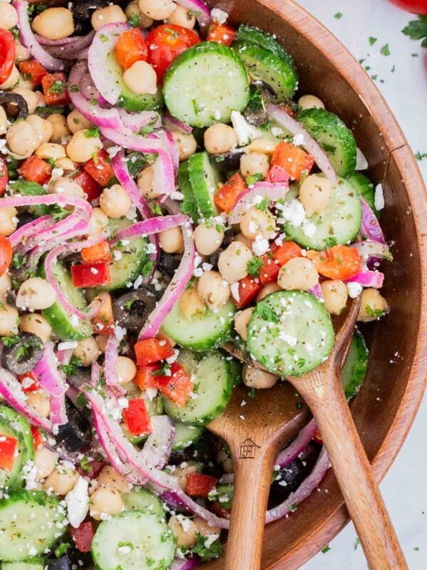 A wooden spoon is used to serve the Mediterranean chickpea salad.