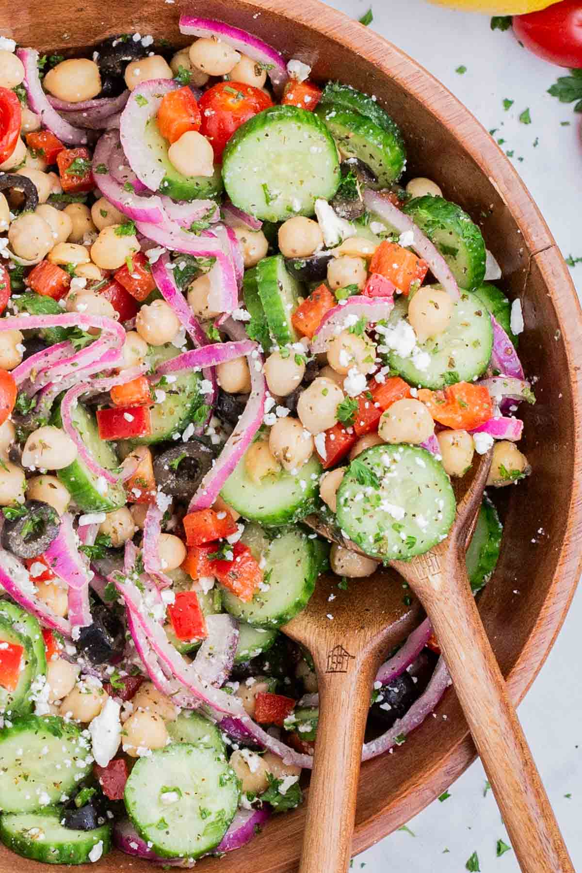 A wooden spoon is used to serve the Mediterranean chickpea salad.