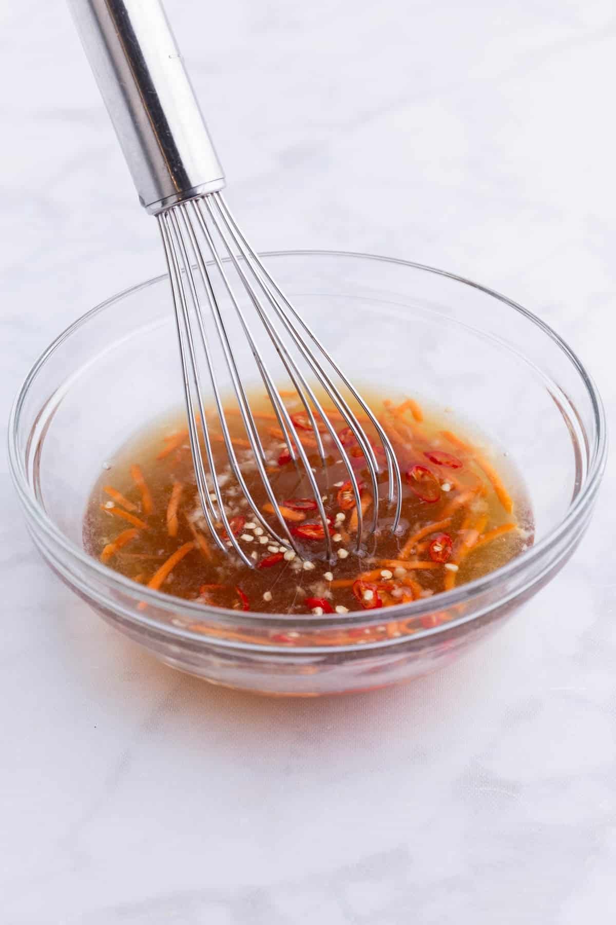 Fish sauce ingredients are whisked together.