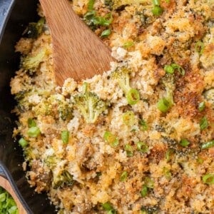 A wooden spoon is used to serve ground turkey broccoli cheese rice.