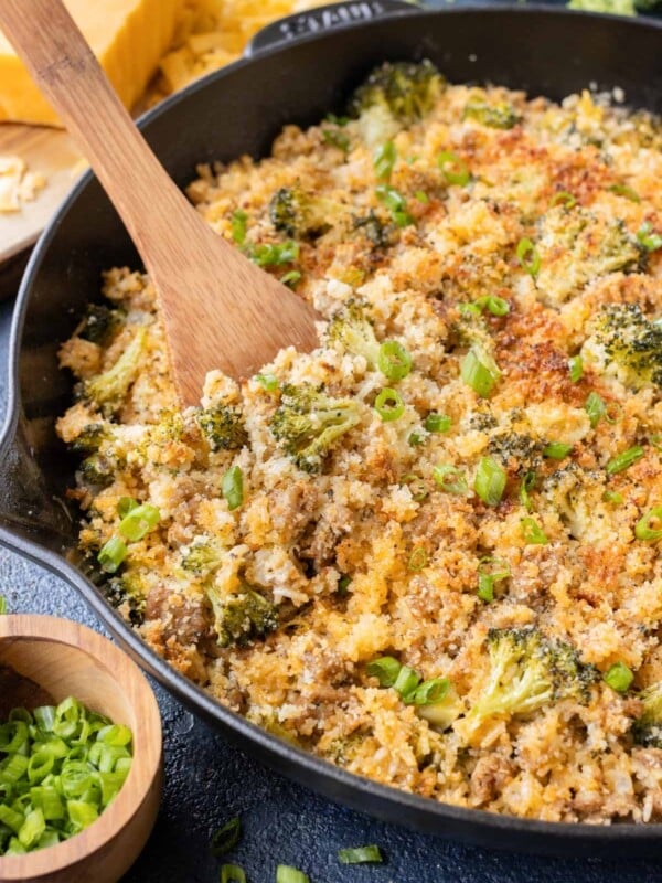 A wooden spoon is used to serve the broccoli rice mixture.