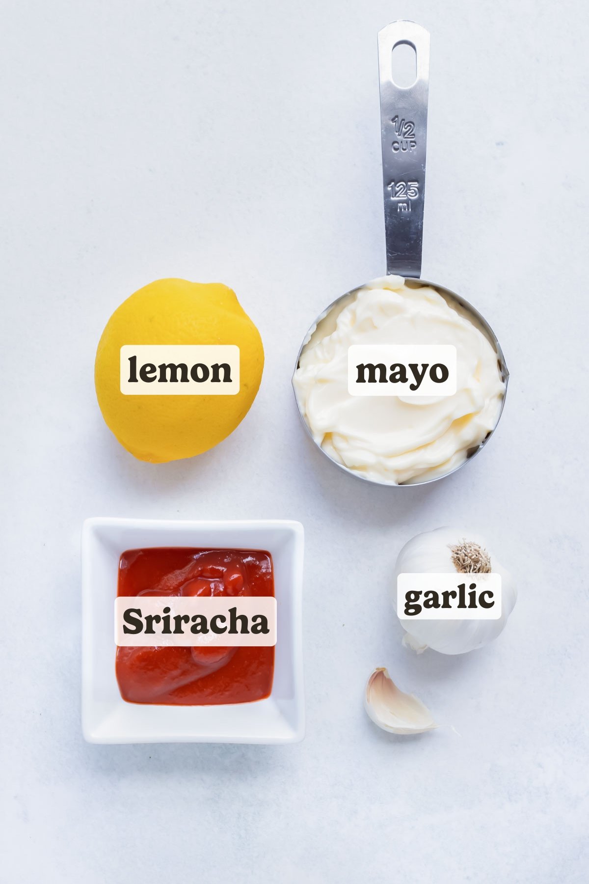 Mayonnaise, Sriracha, garlic, and lemon juice are the ingredients needed for this homemade Sriracha Mayo recipe.