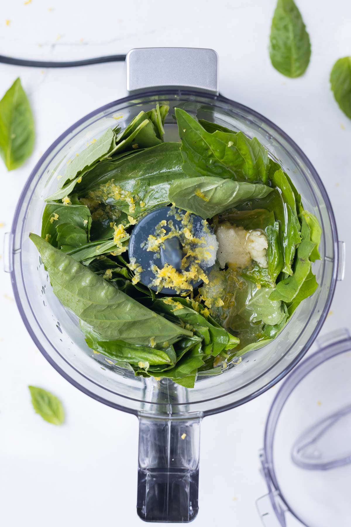 The lemon basil vinaigrette ingredients are added to a food processor.