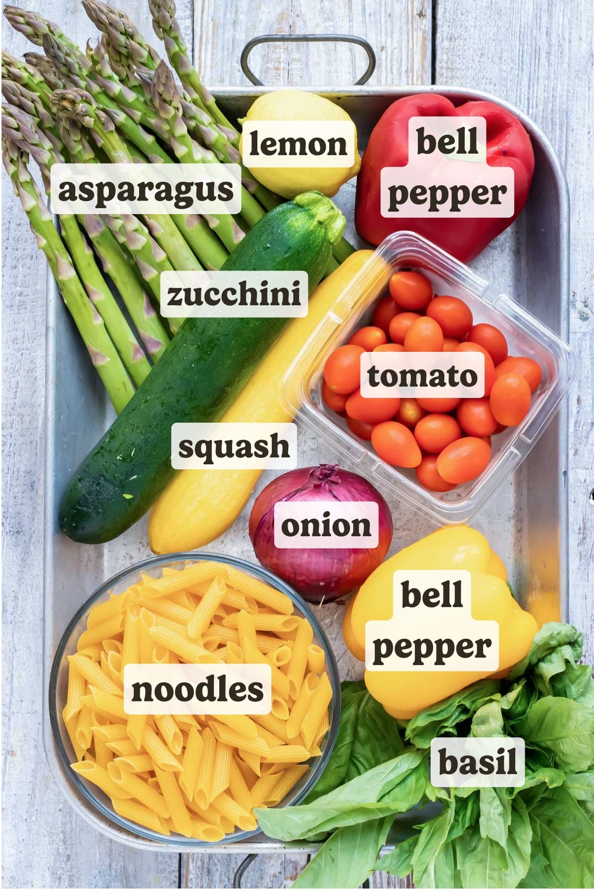 Asparagus, bell pepper, tomatoes, pasta, squash, basil, and lemon as the ingredients for a pasta primavera recipe with lemon butter garlic sauce.