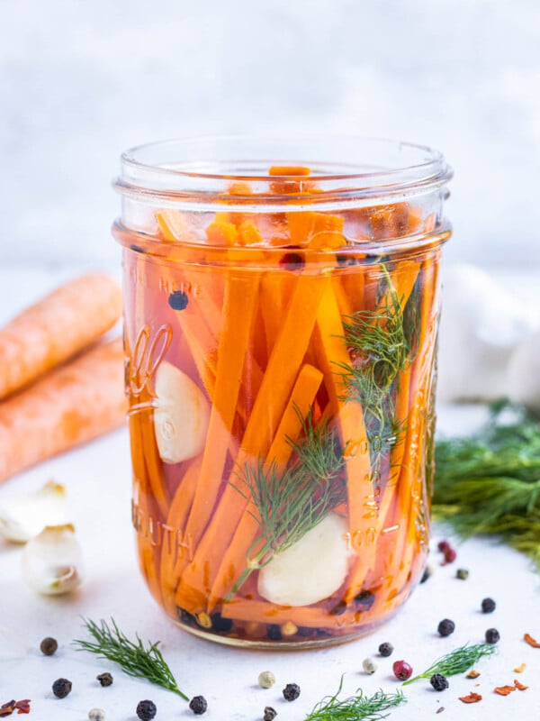 Quick pickled carrots with dill and garlic in a mason jar with a homemade pickling solution.