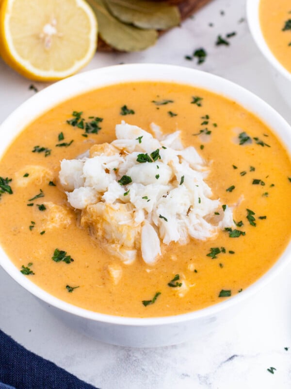 Creamy crab bisque is in a white bowl with jumbo lump crab meat on top.