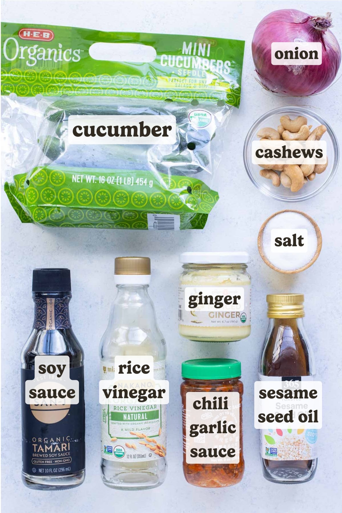 The ingredients for Asian Cucumber Salad include cucumbers, onion, soy sauce, sesame oil, rice wine vinegar, chili garlic paste, and cashews.