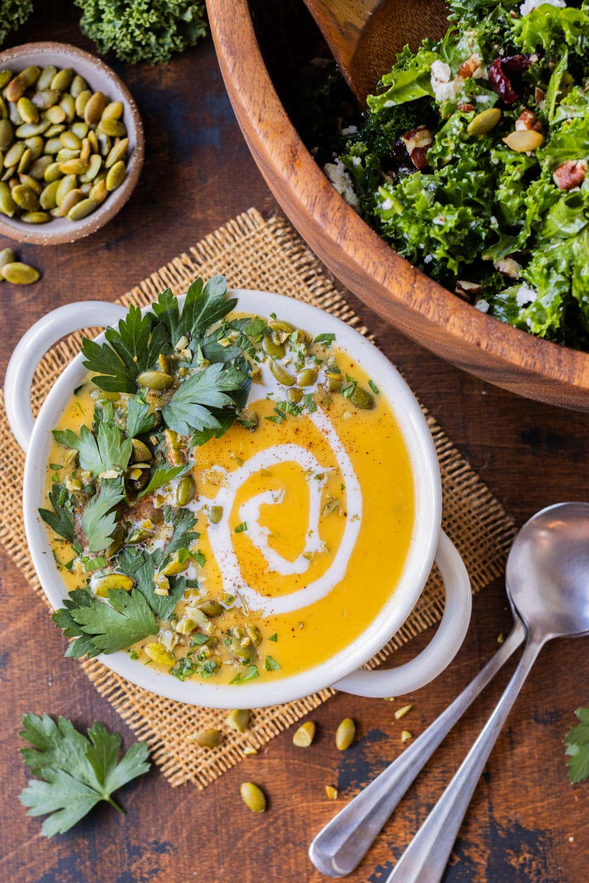 A kale salad and a bowl of butternut squash soup are served for an easy fall dinner.