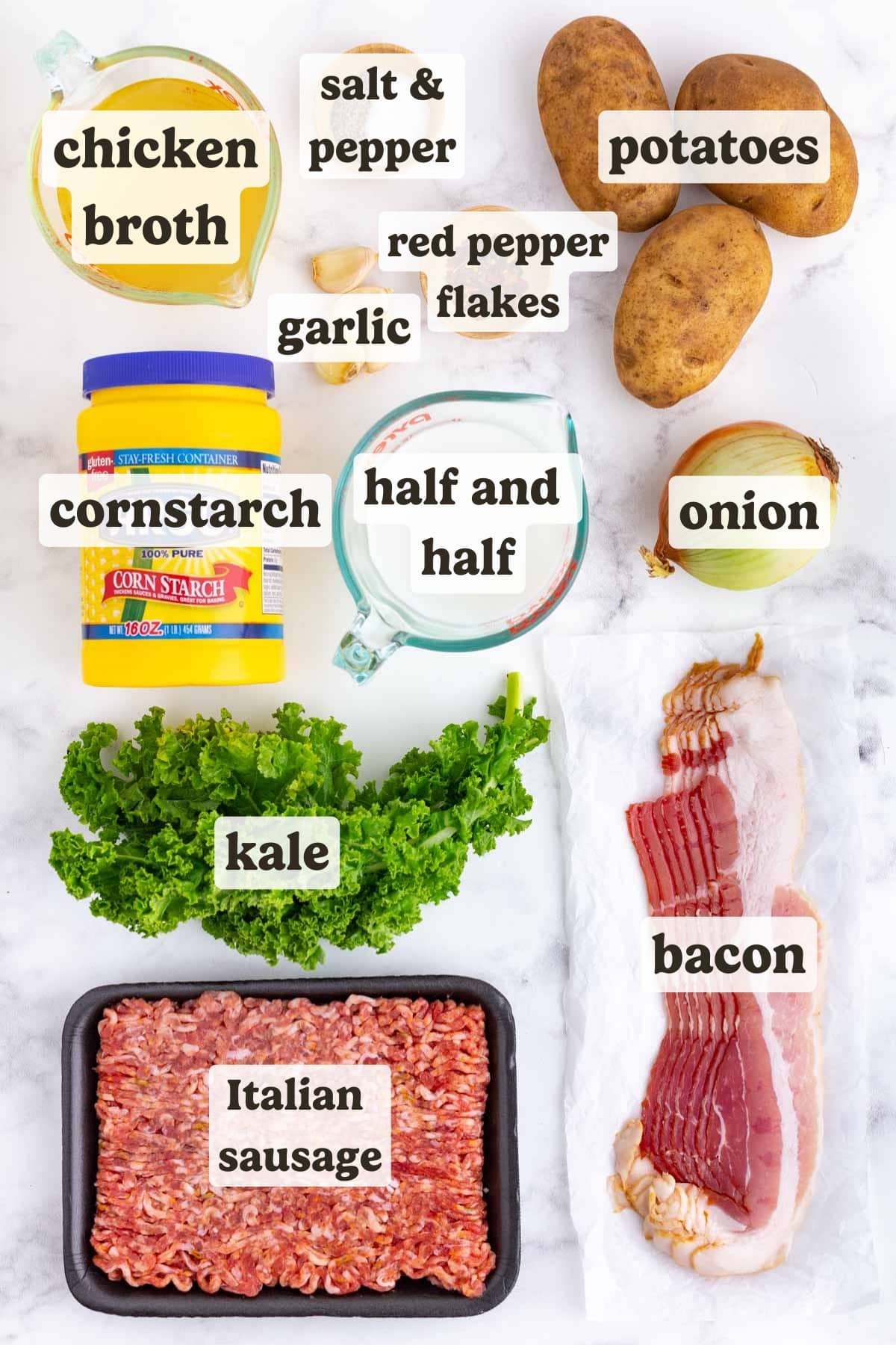 Kale, bacon, potatoes, ground sausage, onion, and red pepper flakes as the ingredients for a zuppa toscana soup.