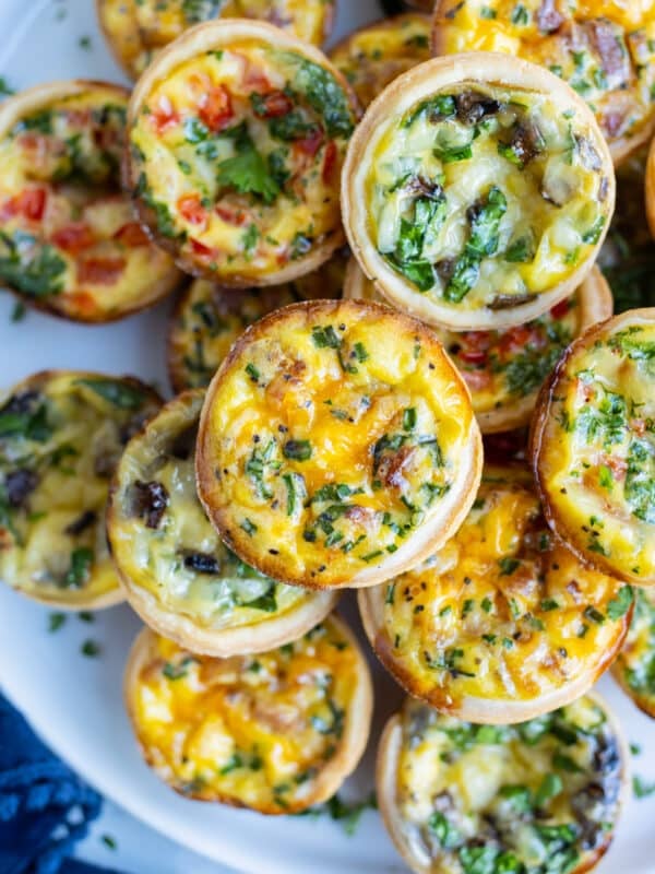 A variety of mini quiches are served on a party tray as a holiday appetizer.