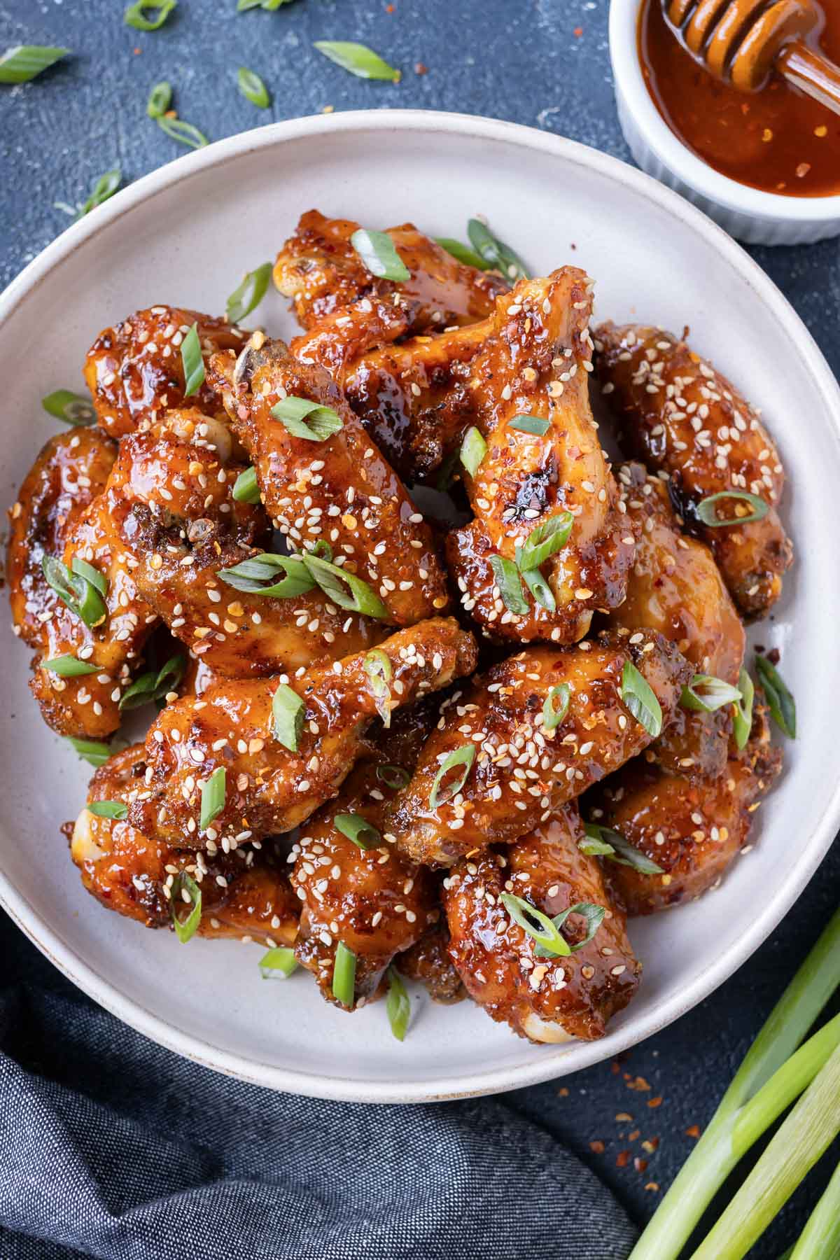 A large platter is piled high with hot honey chicken wings.