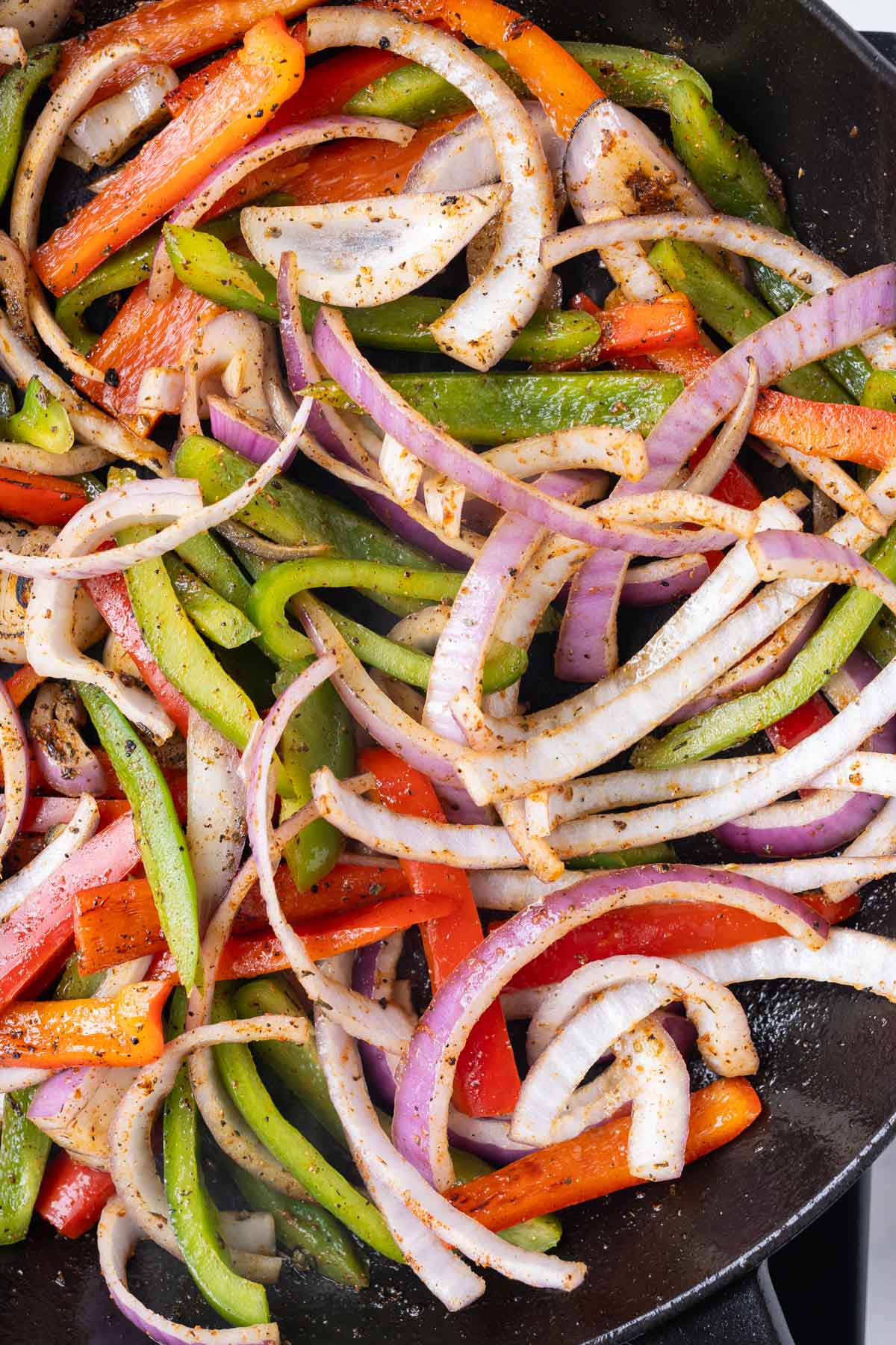 Veggies are cooked in a cast iron skillet.