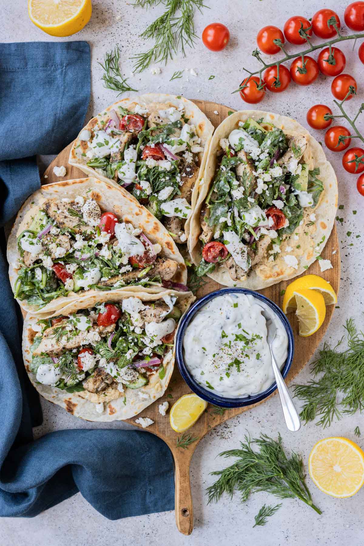Greek chicken tacos are built on a tray.