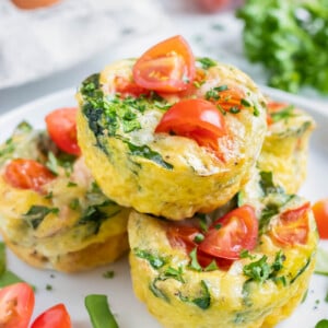 A stack of Spinach Tomato Egg Muffins are served on a breakfast plate.