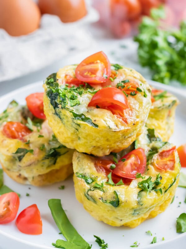 A stack of Spinach Tomato Egg Muffins are served on a breakfast plate.
