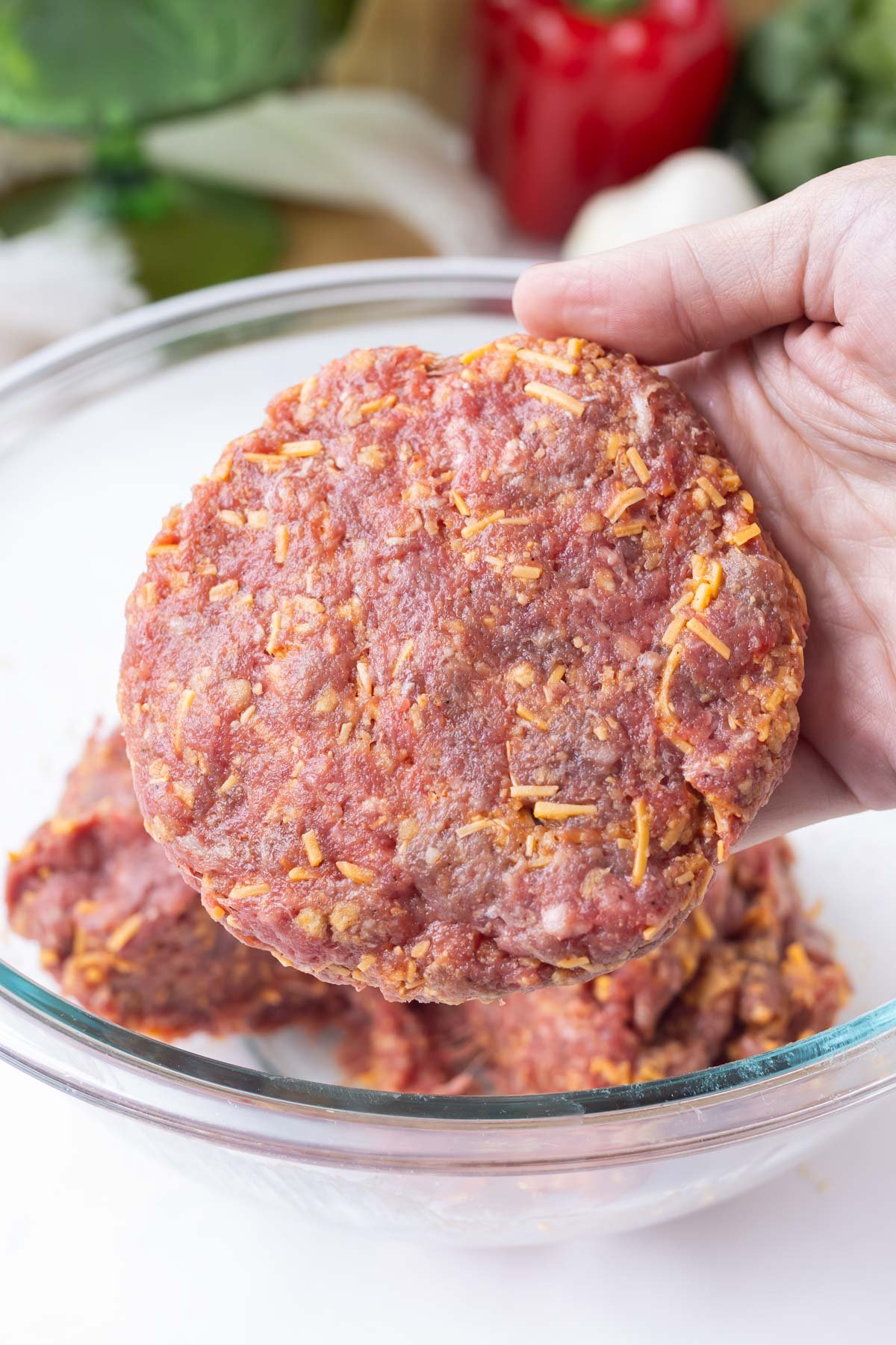 A hand shapes a burger patty.