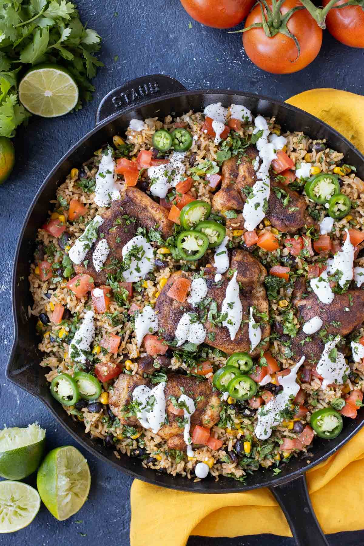 Sauce and jalapenos are added to the chicken and rice skillet.