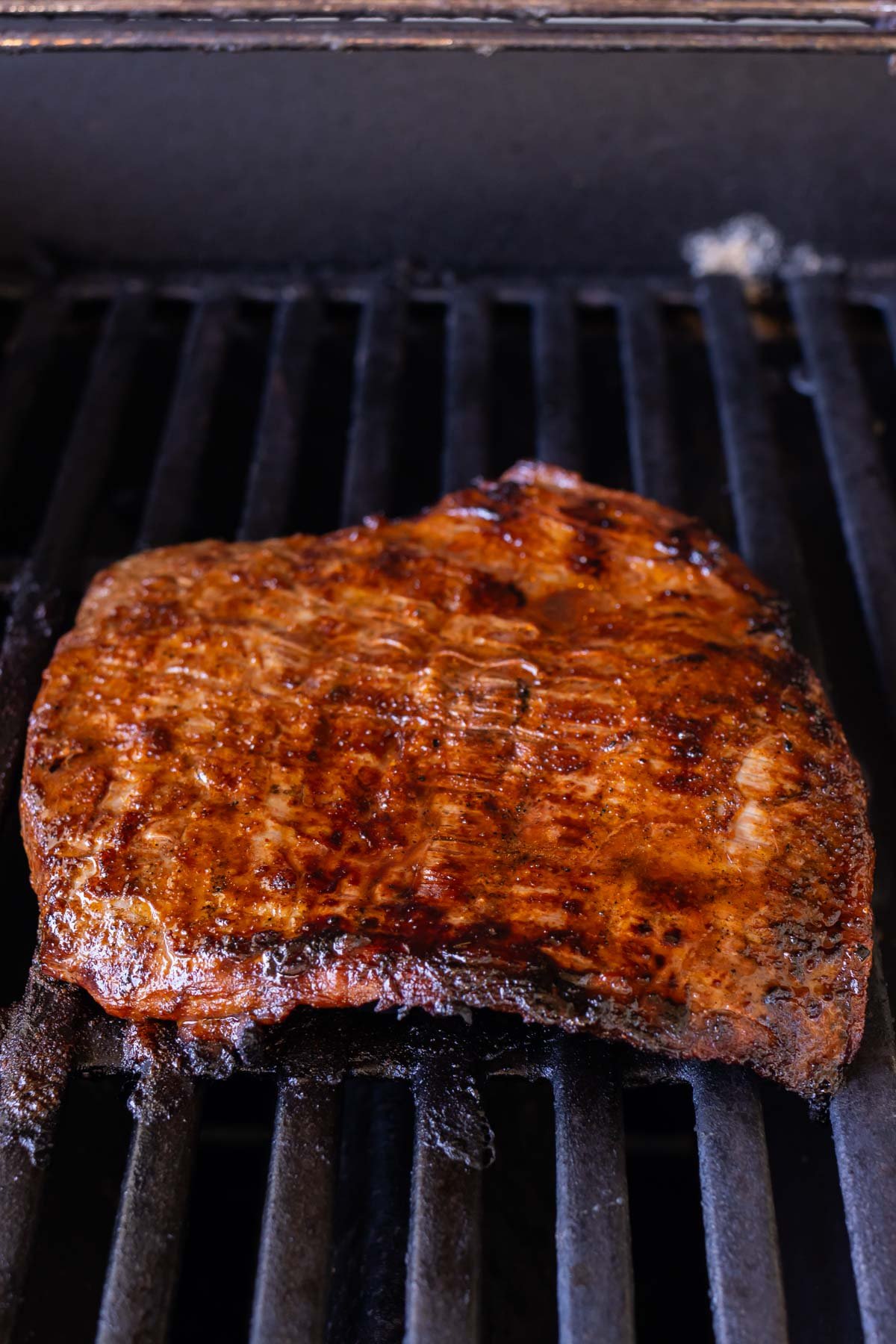 Seasoned fajita steak is cooked on the grill.