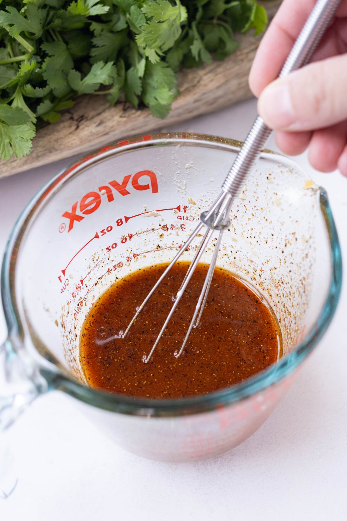 A Korean sauce is whisked in a glass cup.