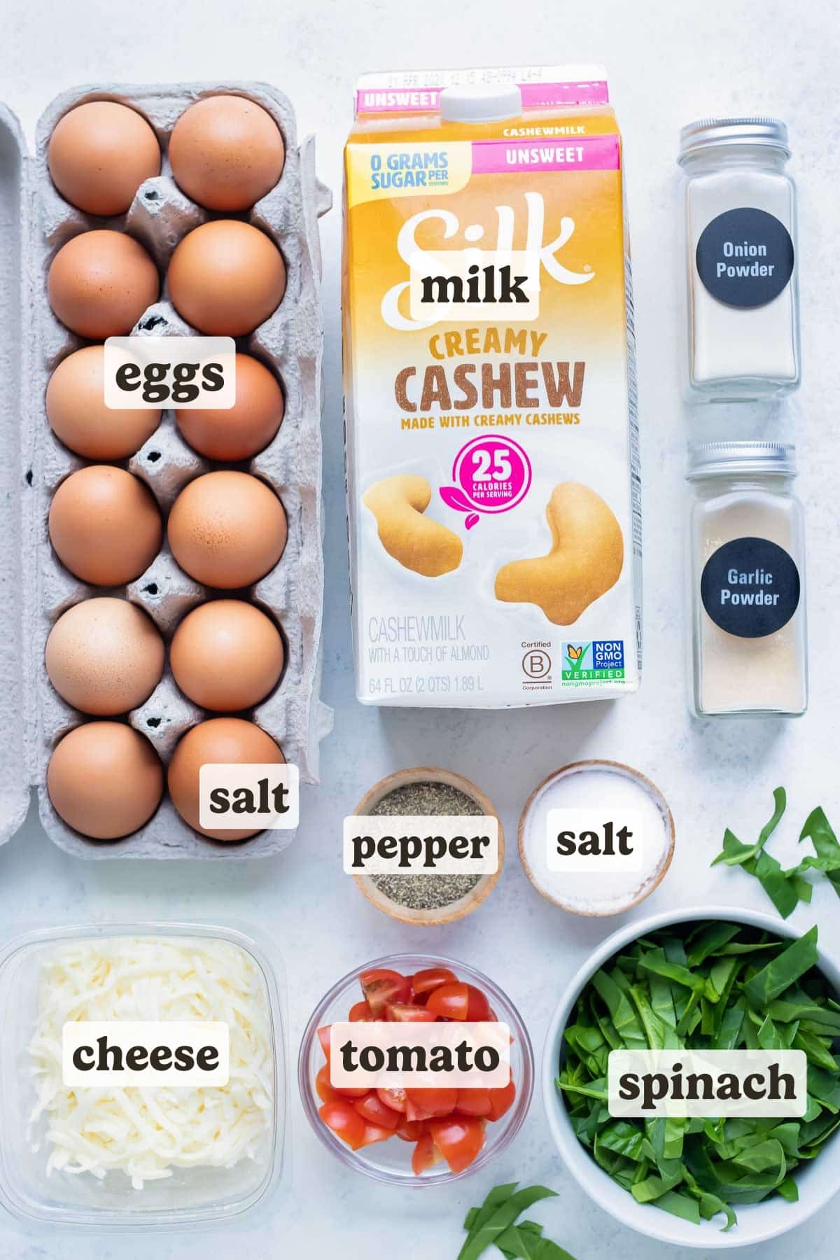 Spinach, tomatoes, cheese, seasonings, milk, and eggs are the ingredients for this egg muffin recipe.