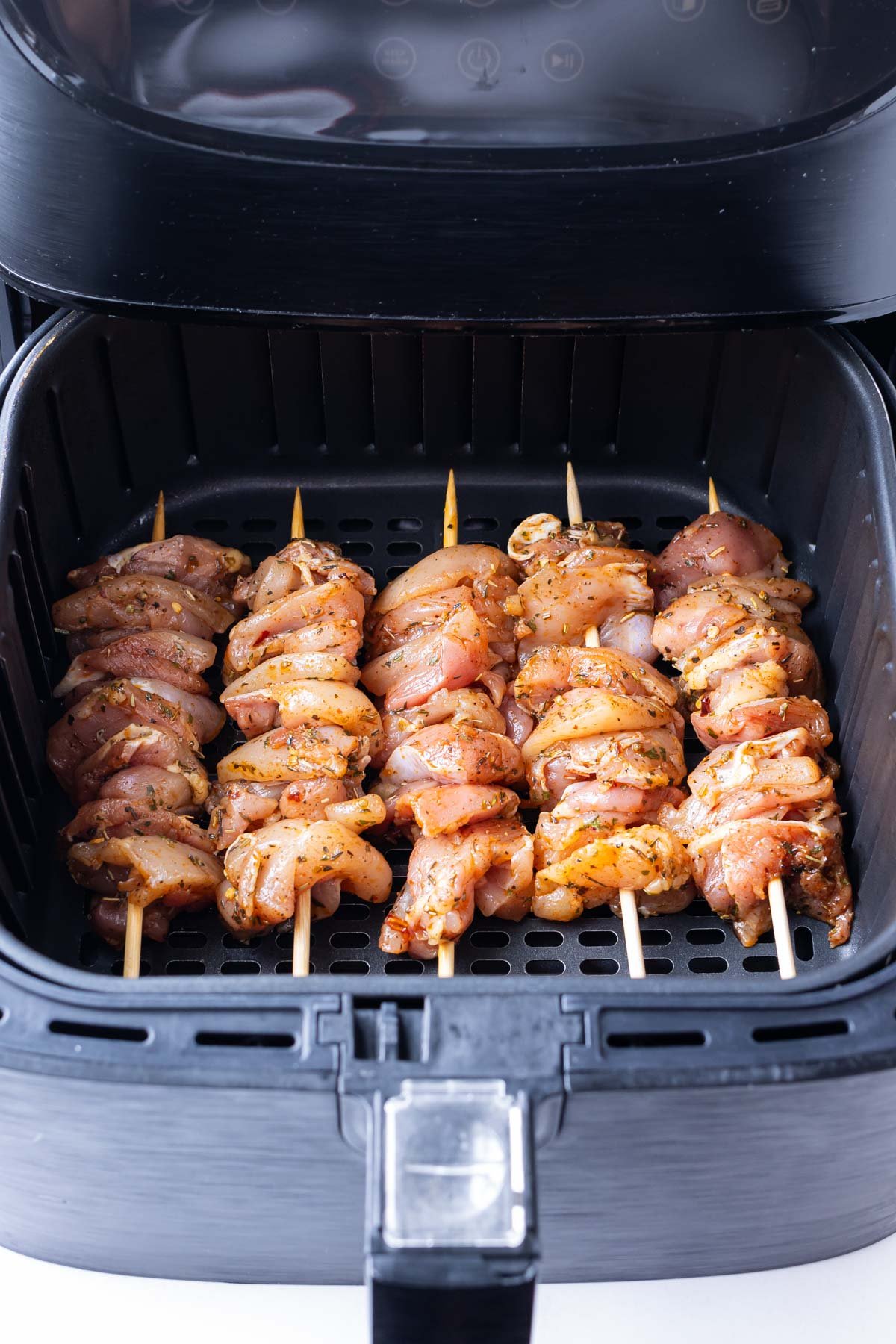 Chicken thighs are skewered and cooked in an air fryer.