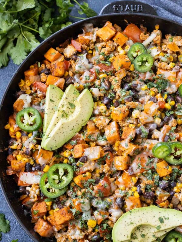 A Sweet Potato Ground Turkey Skillet recipe is served with avocado, jalapenos, and cilantro for dinner.