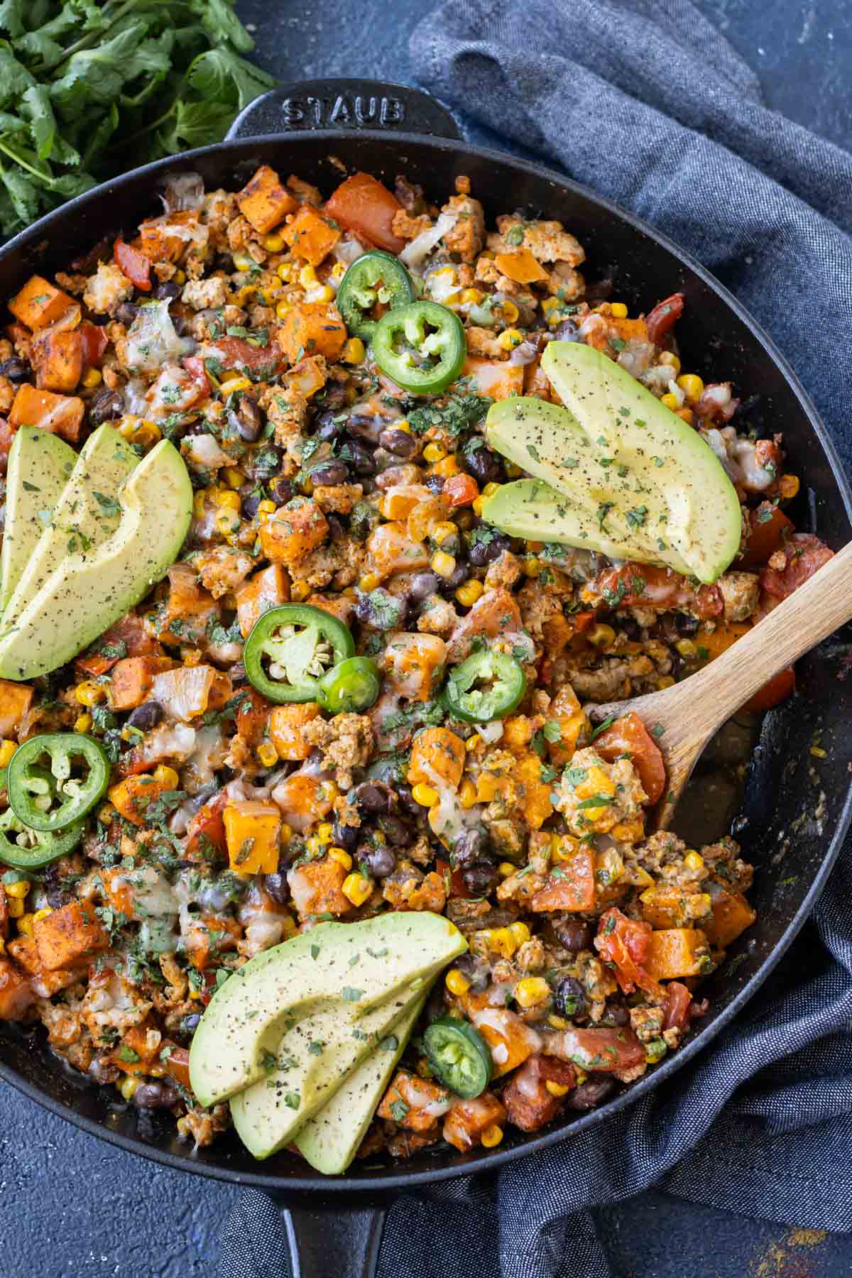 A big skillet is full of a ground turkey and sweet potato recipe with corn, black beans, cilantro, and cheese for dinner.