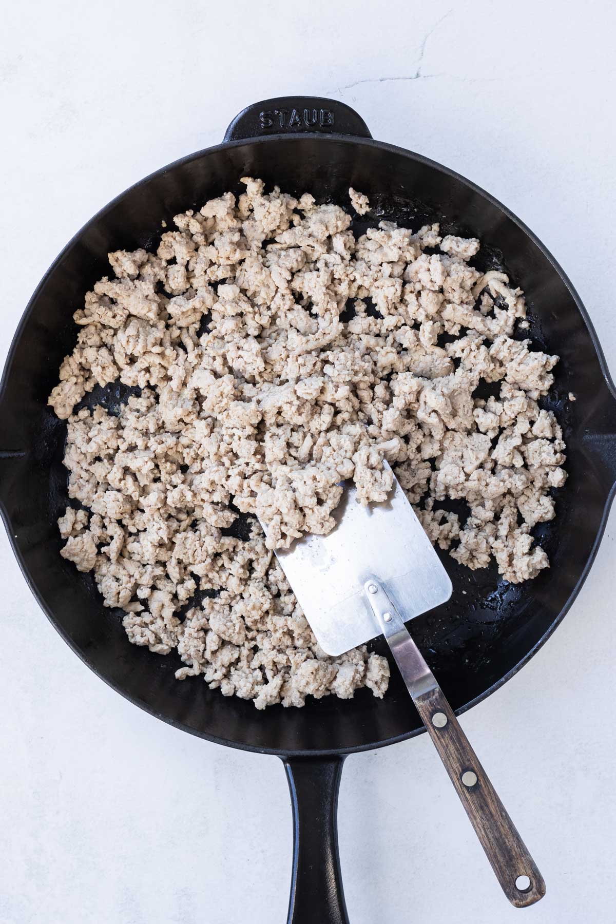 Ground turkey is cooked in a cast iron skillet.