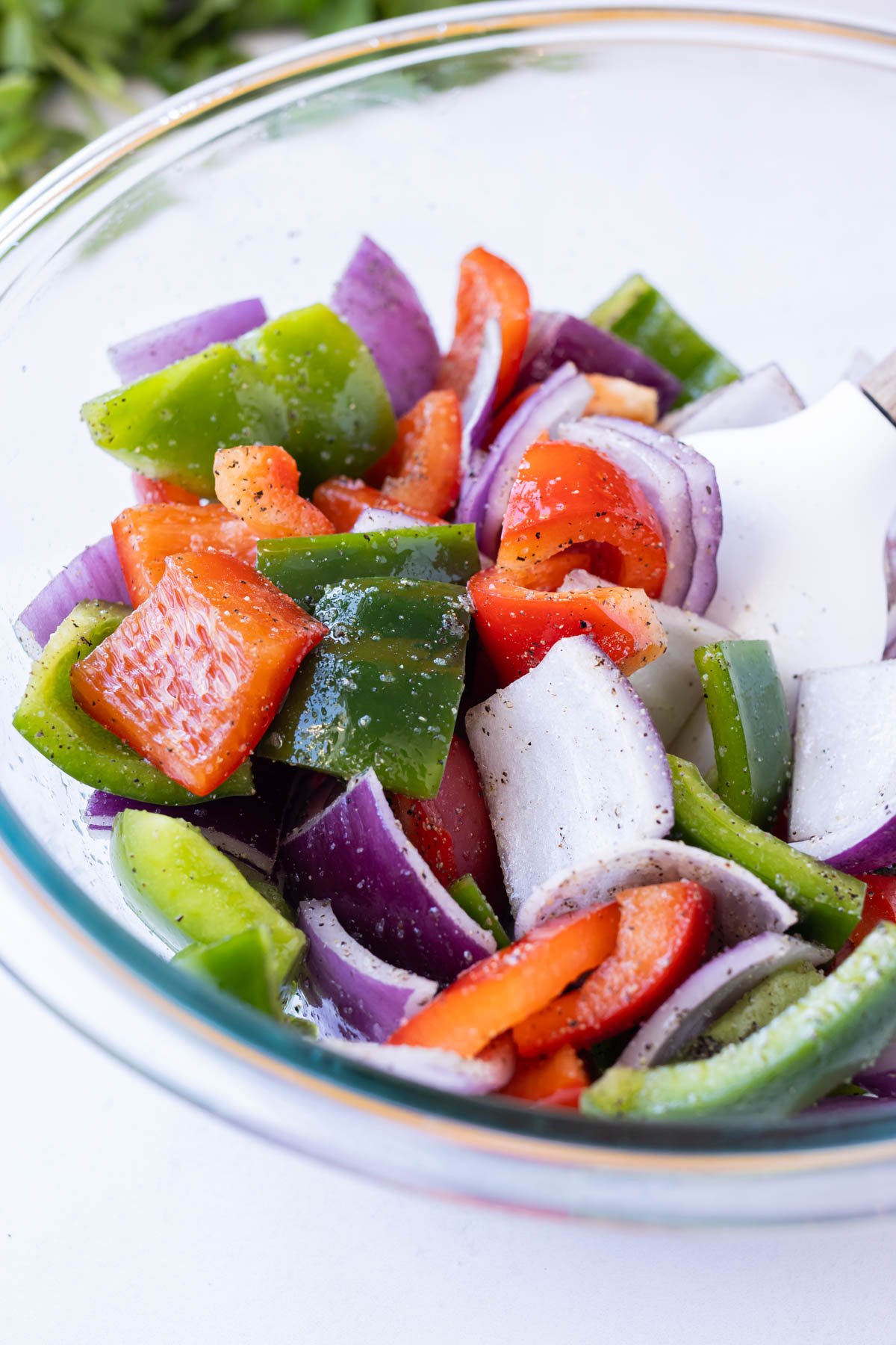 A bowl is full of sliced veggies for the chicken kebabs.