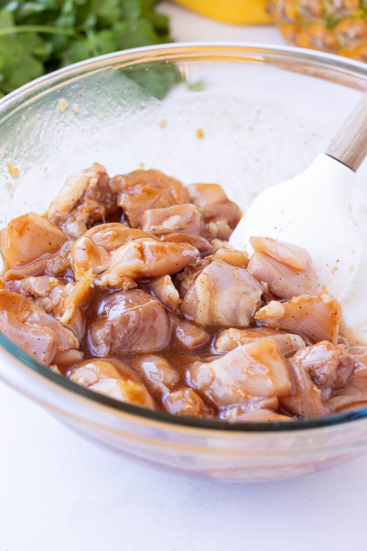 Chicken chunks are stirred with a sauce to marinate.