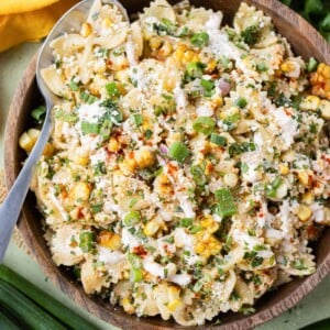 A wooden bowl is loaded up with Mexican street corn pasta salad.